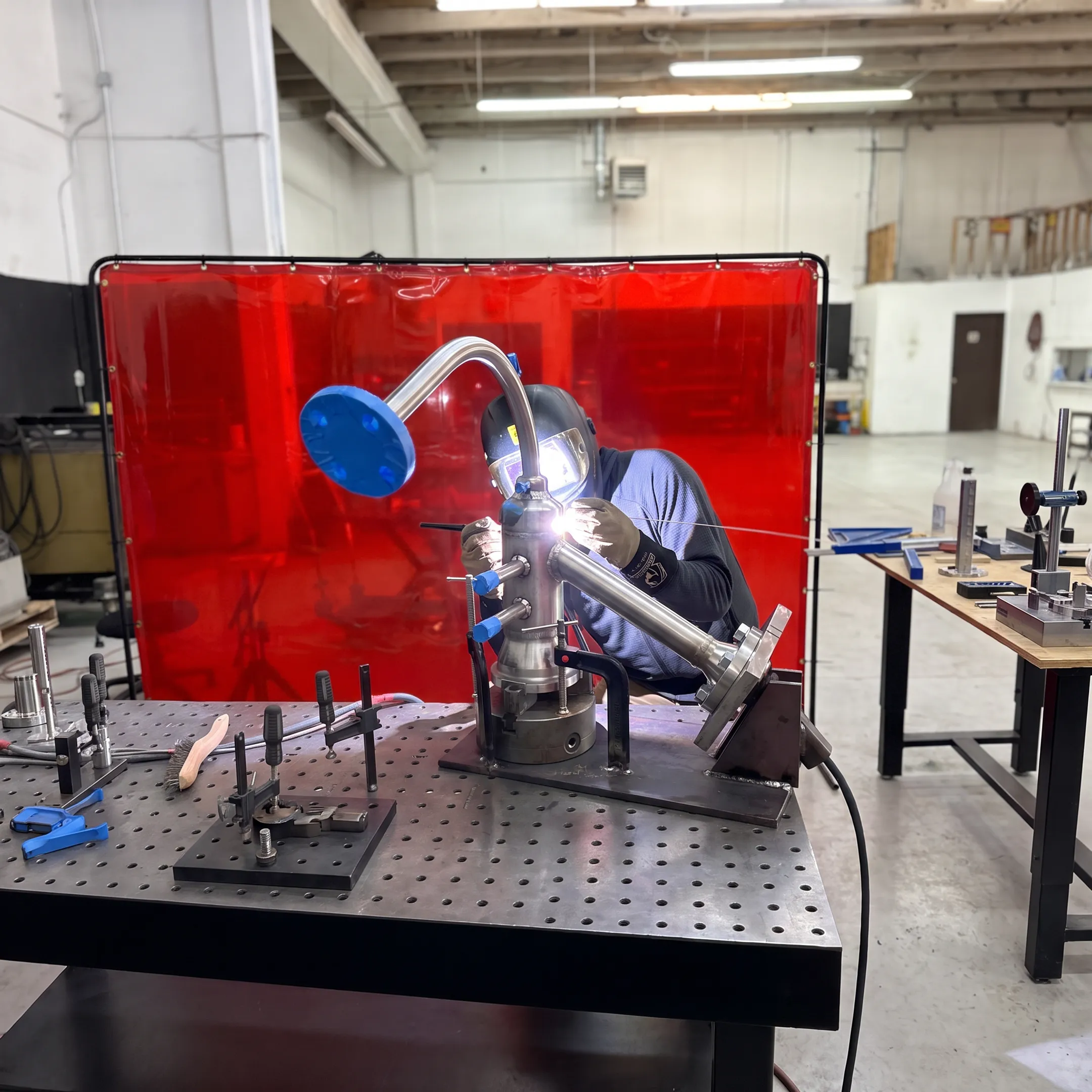 Welder fabricating an advanced alloy component in a controlled workshop