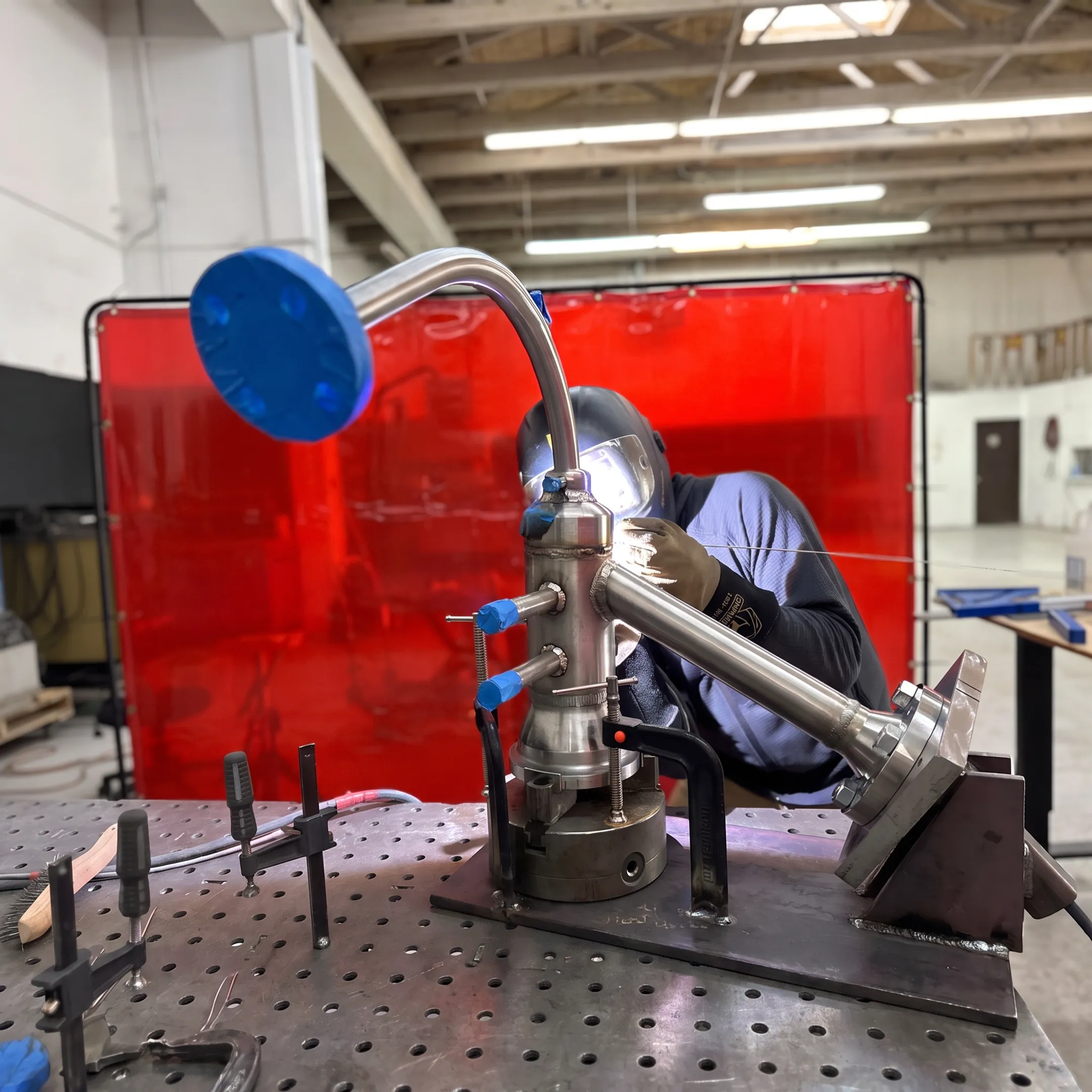 Technician welding stainless steel industrial piping