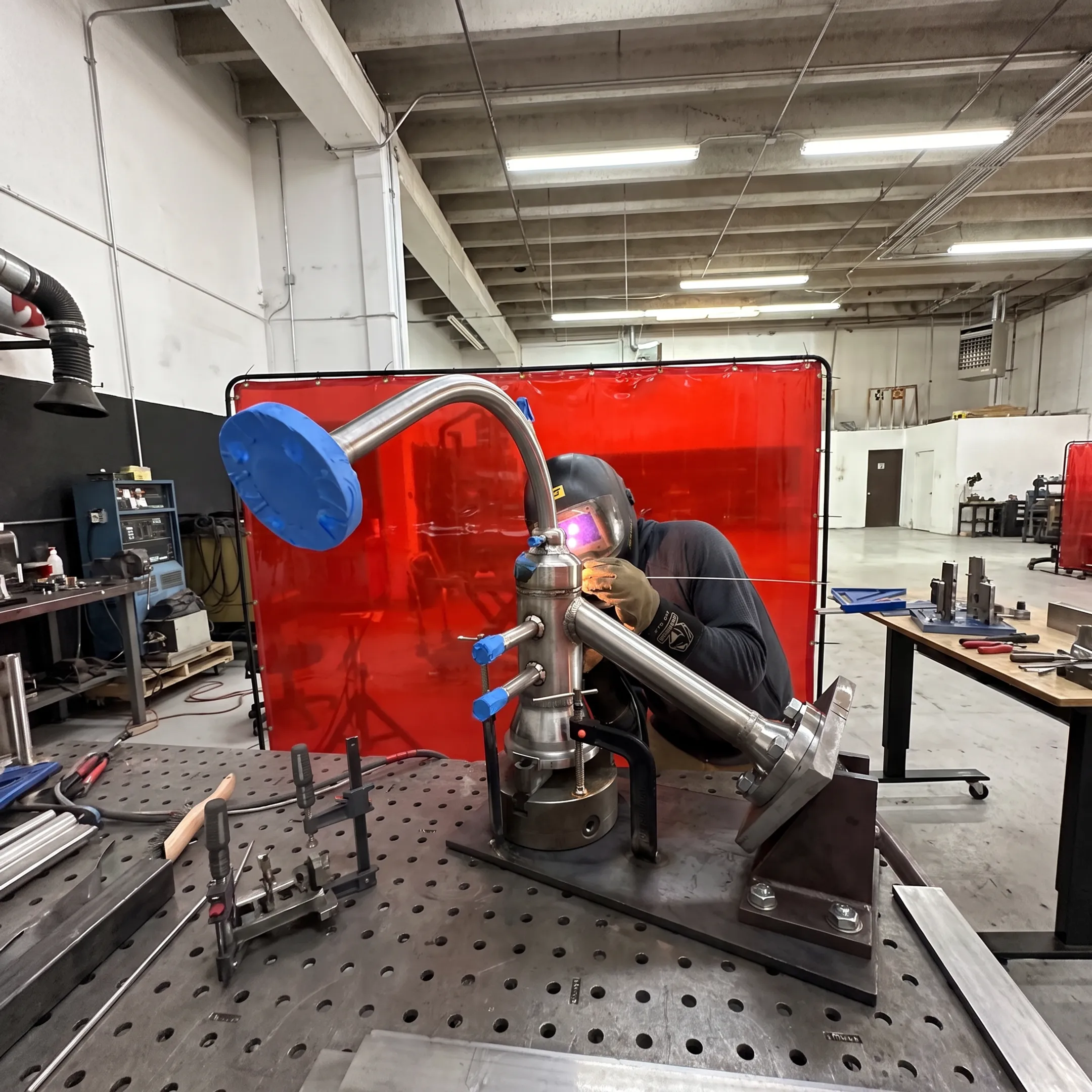 Welder performing precision TIG welding on a specialty alloy industrial assembly