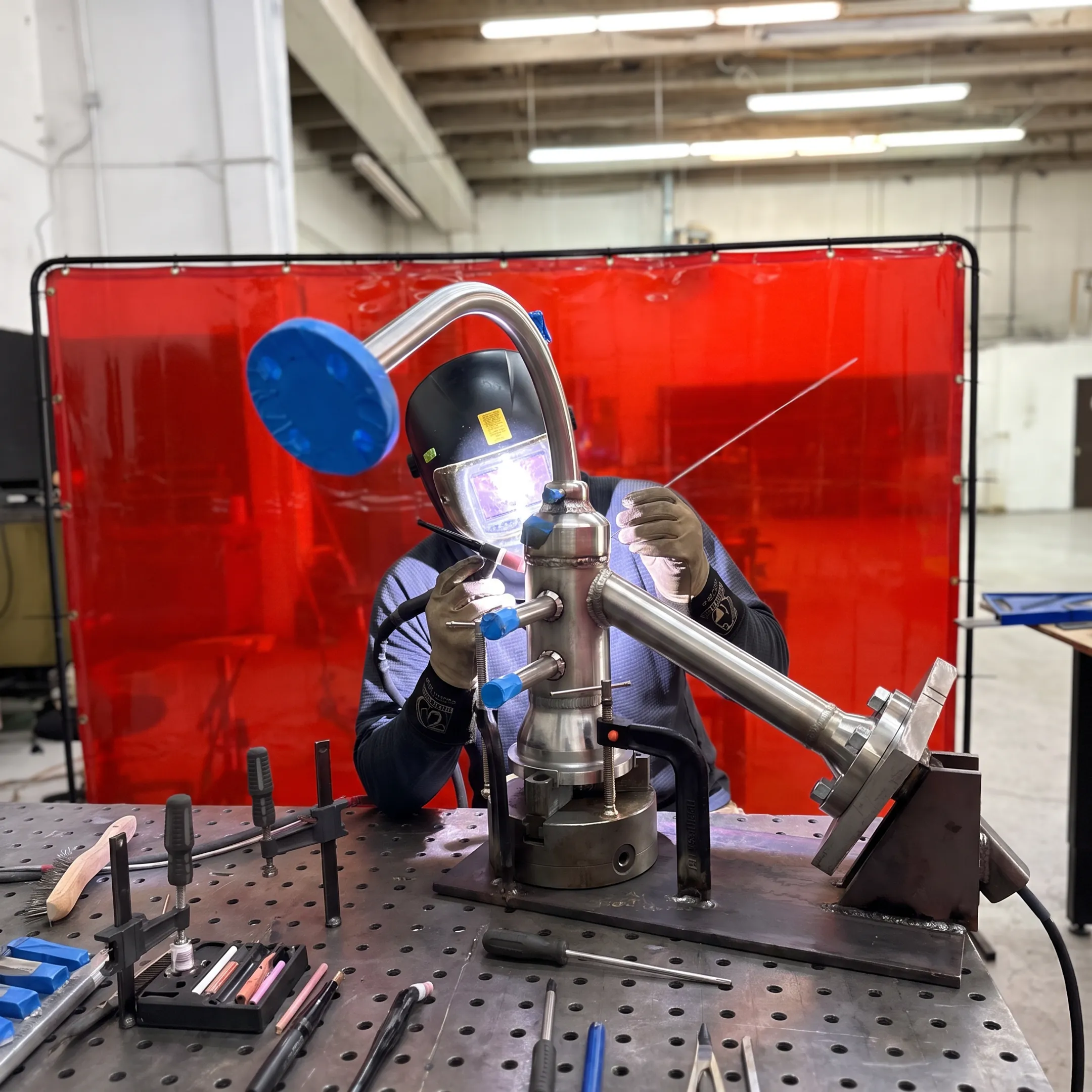 Precision welder fabricating a specialty alloy assembly in a controlled workshop
