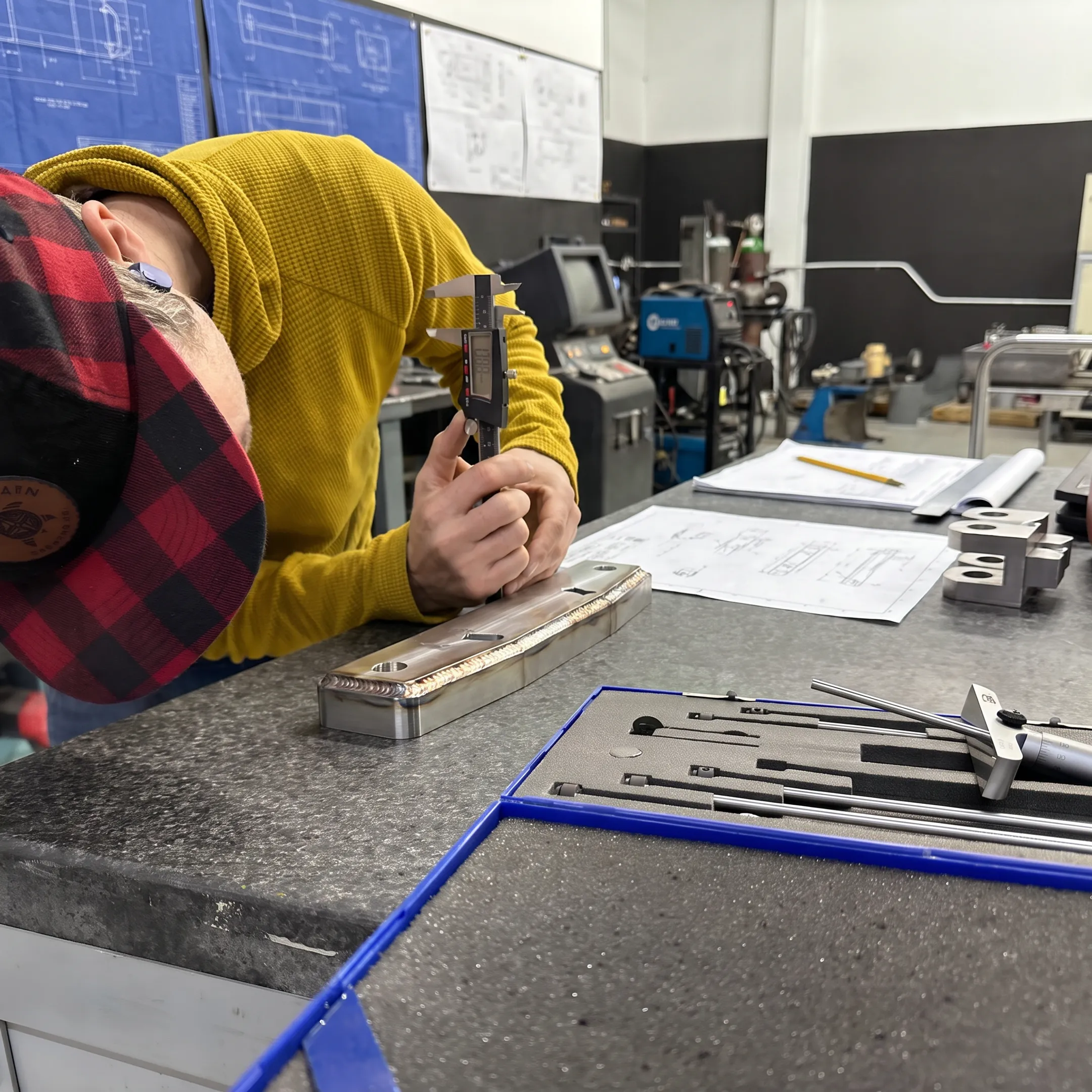 Engineer reviewing a precision welded metal assembly