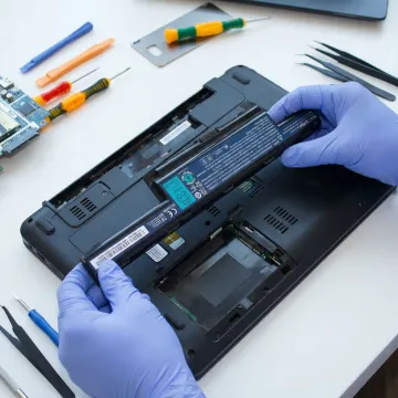 Close-up of a new laptop battery being installed by a technician
