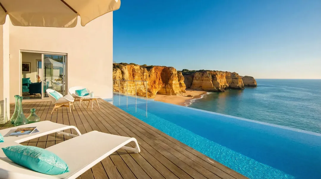 Algarve coastal apartment complex with pool overlooking turquoise ocean in southern Portugal