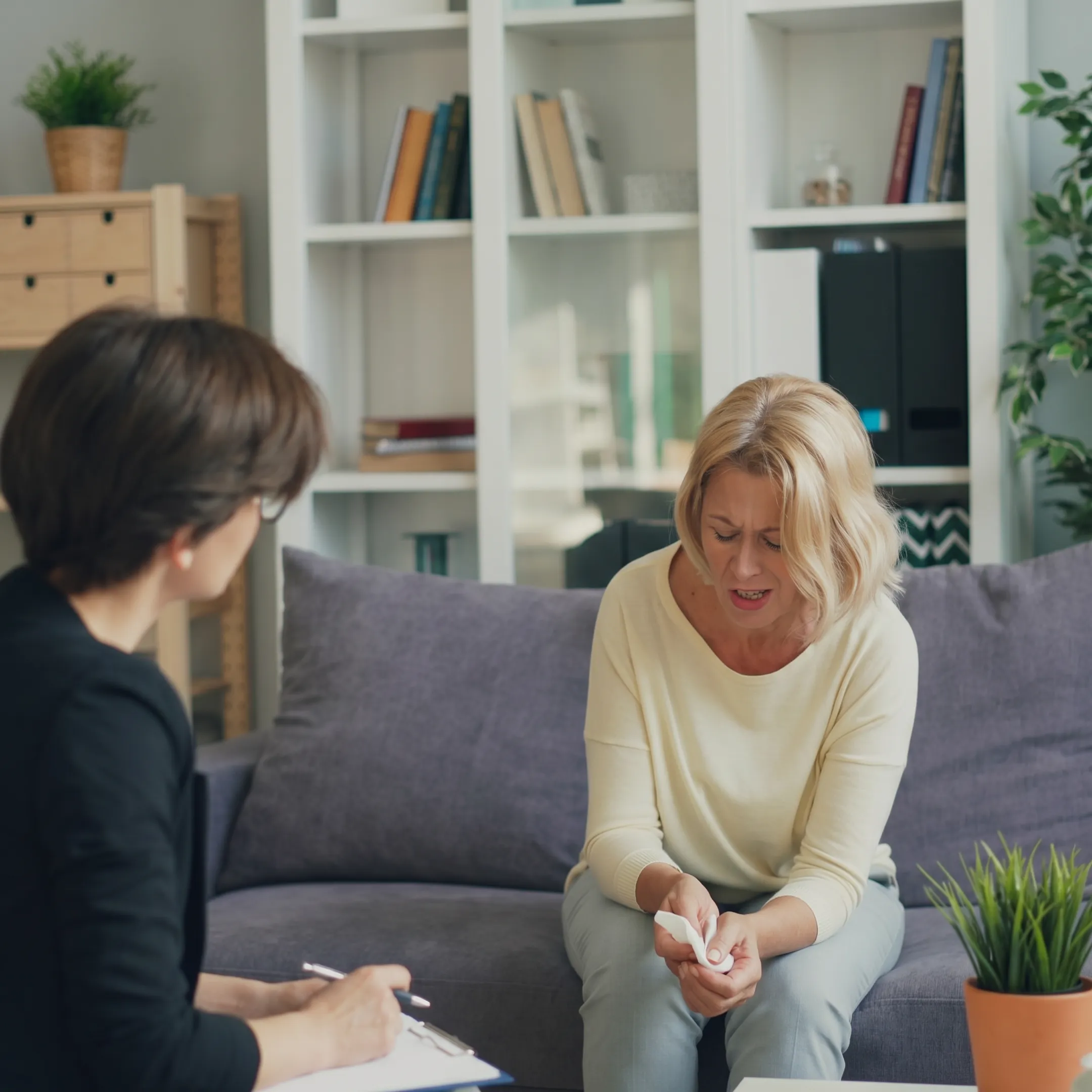 Compassionate behavioral health clinician speaking with an adult client in a calm California treatment setting