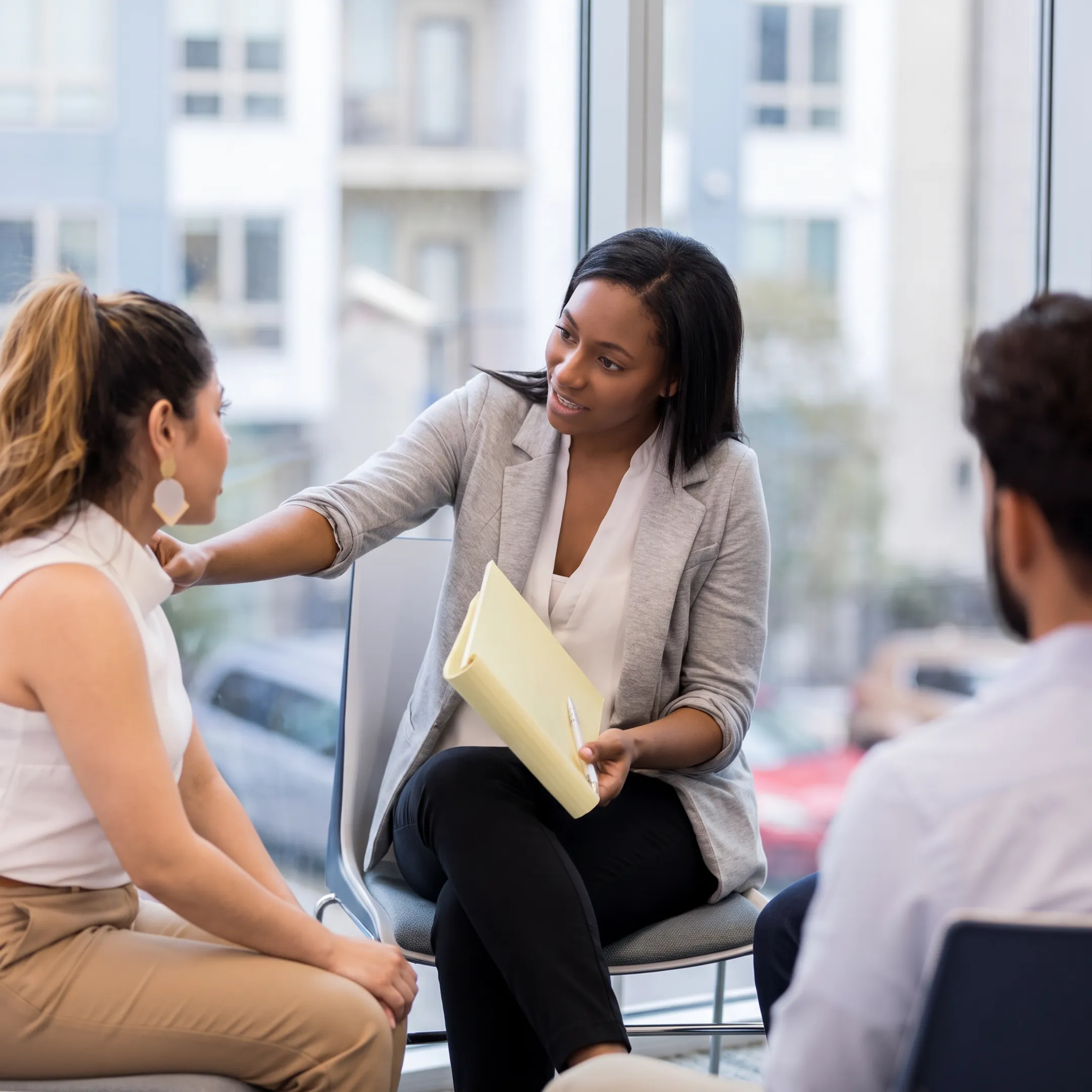 Clinician speaking with an adult client in a calm behavioral health treatment setting