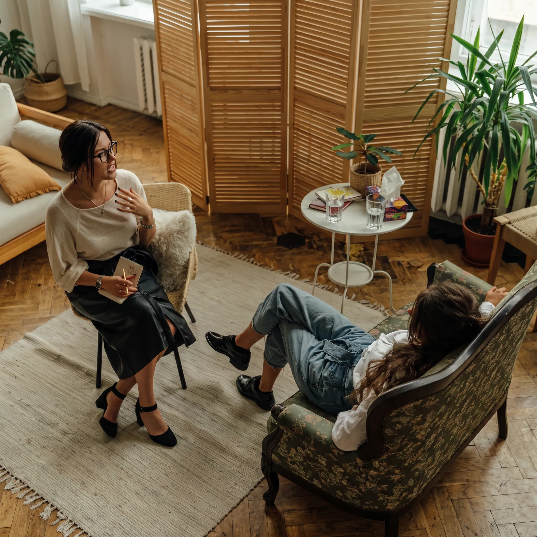 Clinician speaking with an adult receiving inpatient depression treatment in a calm residential setting