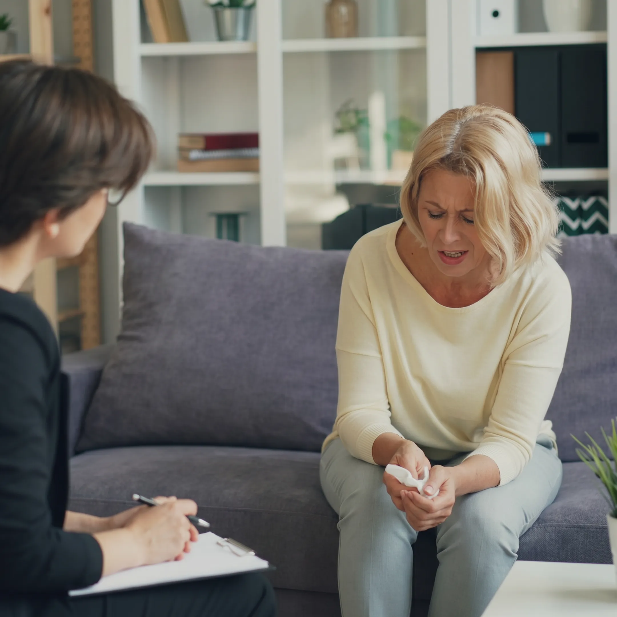Young adult speaking with a behavioral health counselor in a calm transitional living setting