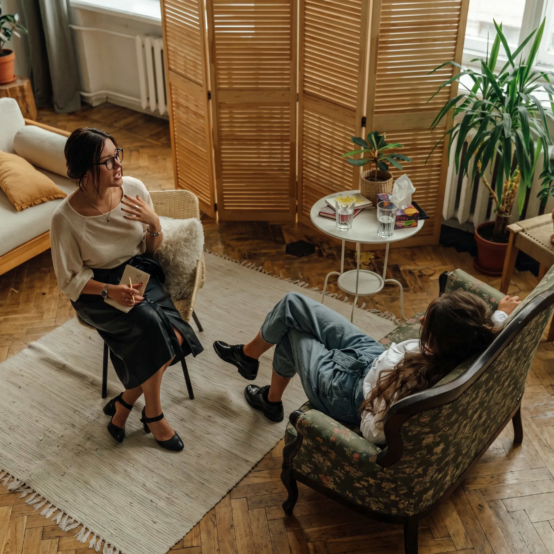 Therapist speaking with an adult client in a calm behavioral health treatment setting