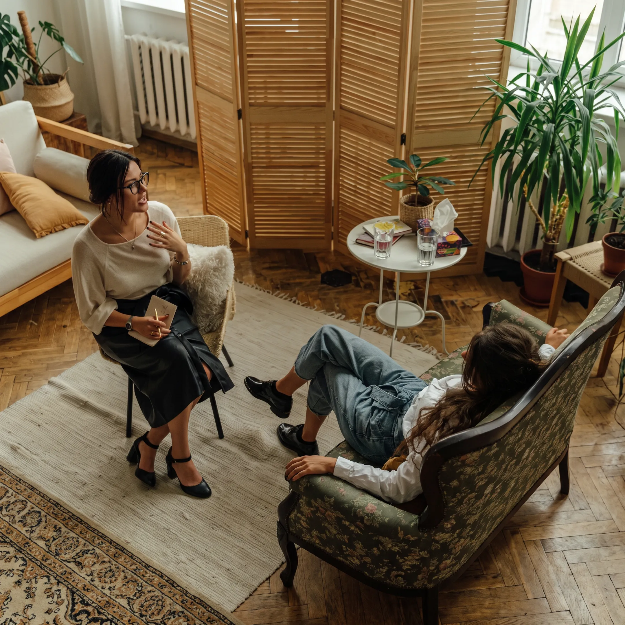 Clinician speaking with an adult client in a calm mental health treatment setting