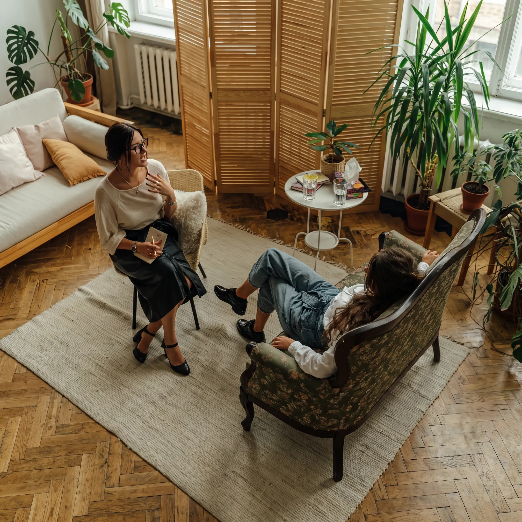 Therapist speaking with an adult client in a calm treatment setting