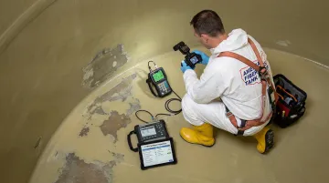 AFTR certified inspector performing non-destructive testing on fiberglass tank interior liner