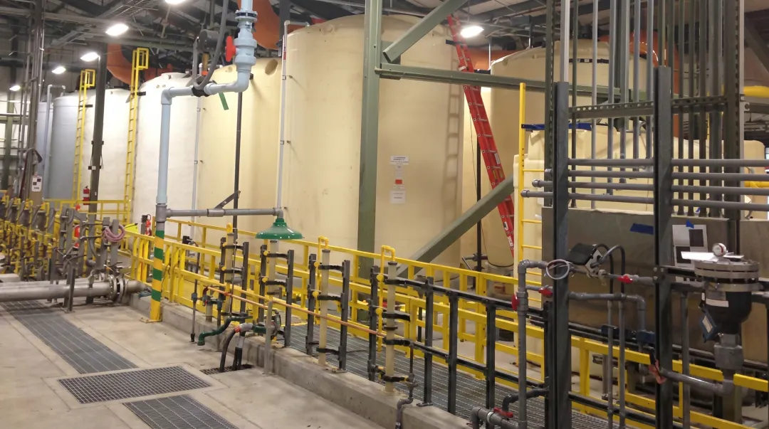 Industrial water treatment facility with large FRP chemical storage tanks installed outdoors