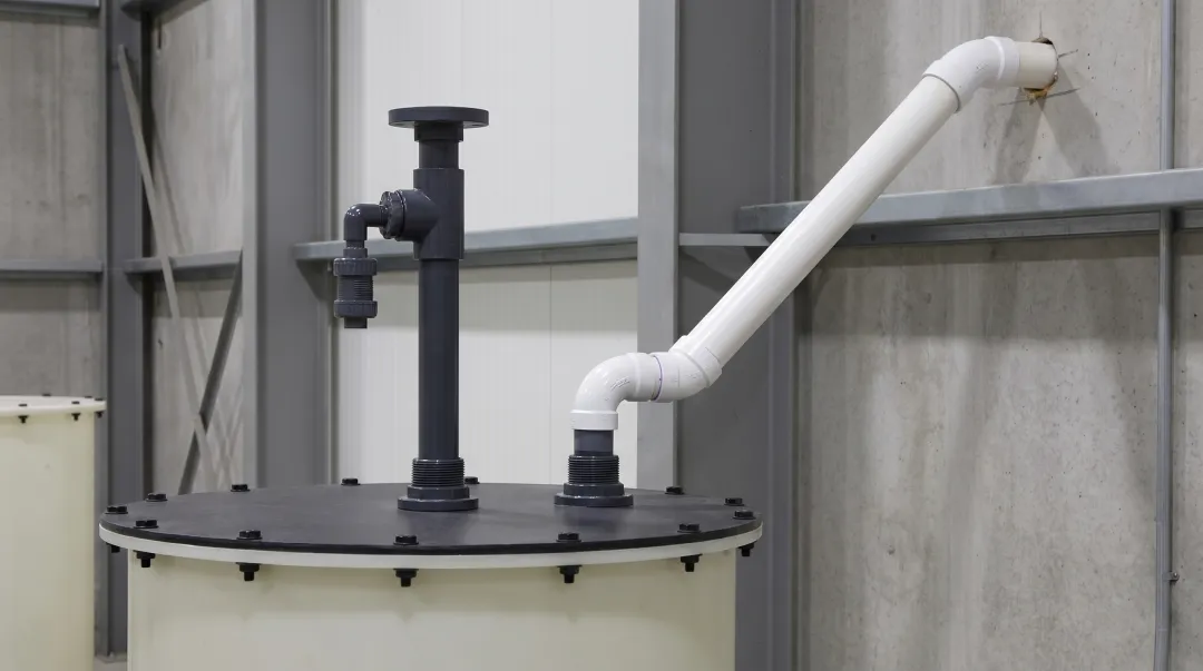 Industrial PVC vent pipe system installed on chemical storage tank exterior