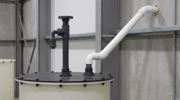 Industrial PVC vent pipe system installed on chemical storage tank exterior