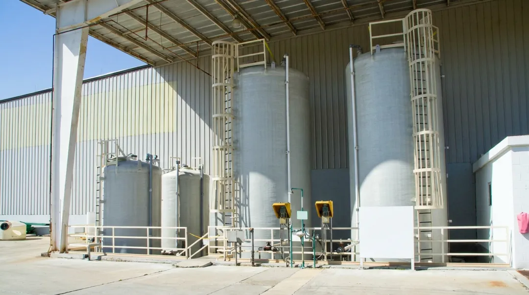 Large industrial fiberglass FRP storage tanks at chemical or water treatment facility