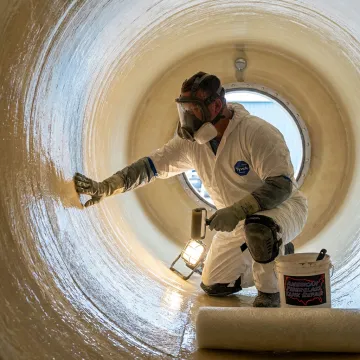Technician inspecting FRP tank trailer lining