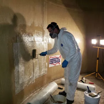 Technician applying fiberglass tank lining