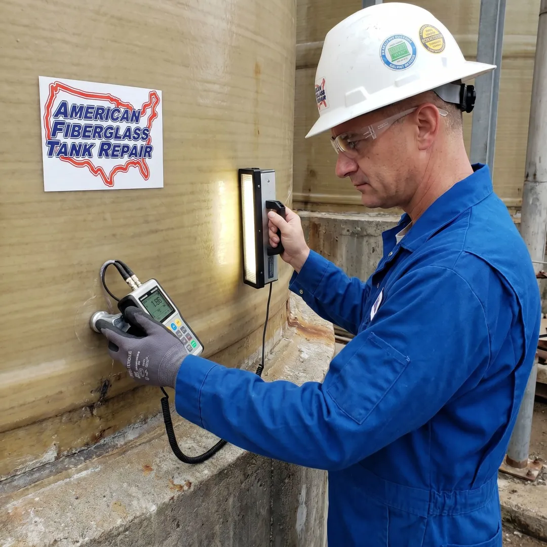 Inspector using testing equipment on an FRP tank wall