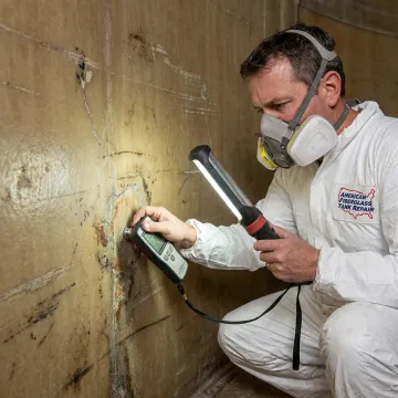 Technician testing fiberglass tank condition