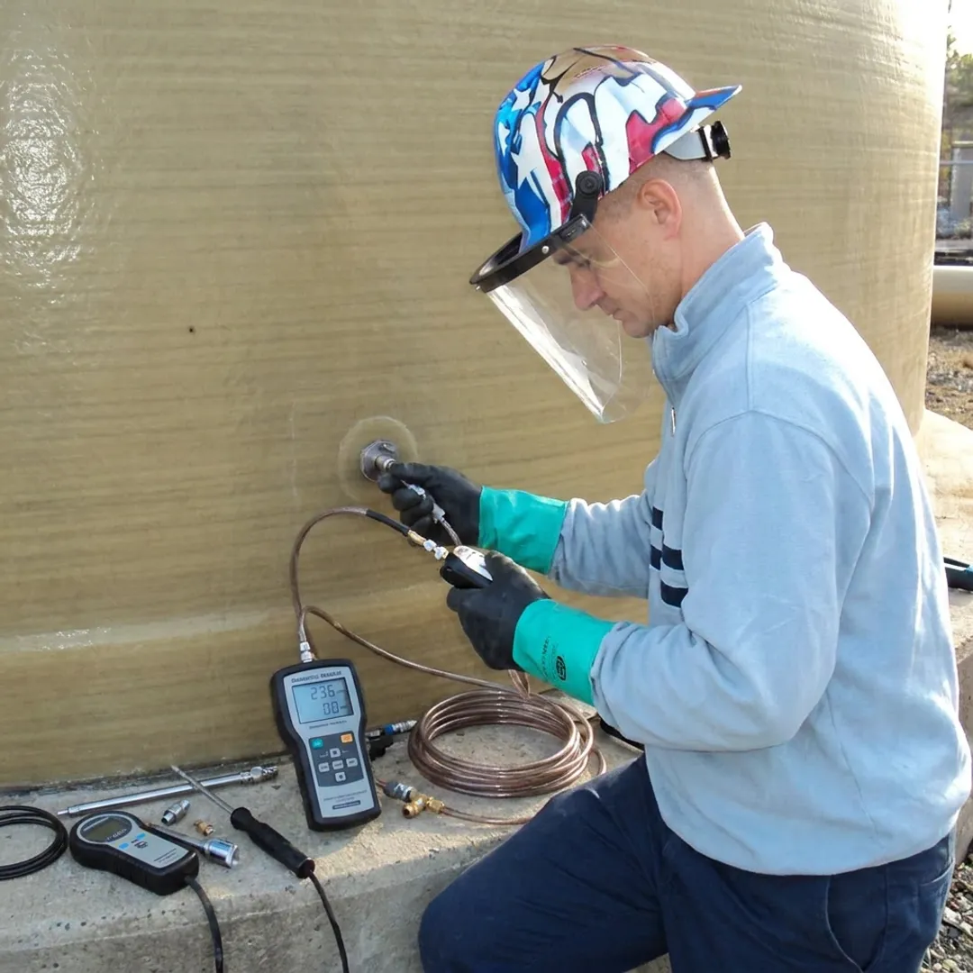 FRP tank technician testing leak detection equipment