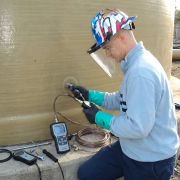 FRP tank technician testing leak detection equipment