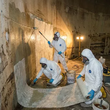 FRP repair crew working inside a fiberglass storage tank