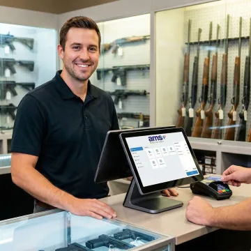 Gun shop owner using a point of sale system at the counter with firearms displayed behind
