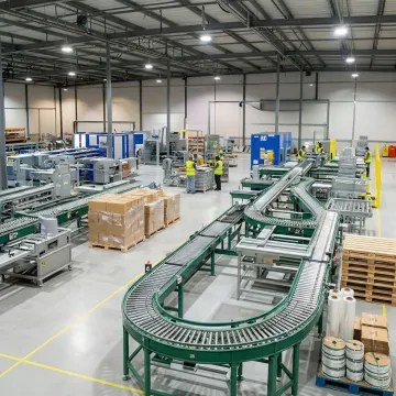 Custom industrial packaging solutions and conveyor systems in modern warehouse facility
