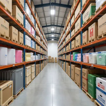Custom industrial packaging materials and corrugated boxes on warehouse shelving