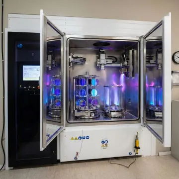 Precision optical coating equipment applying anti-reflective treatments to glass components