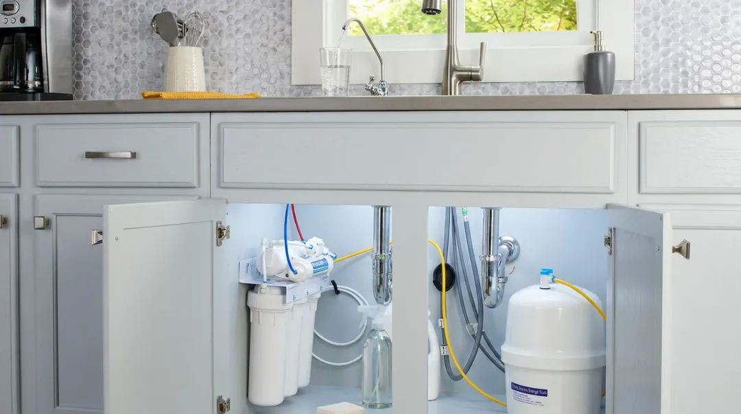 Under-sink reverse osmosis system installed beneath kitchen sink with filtered water faucet