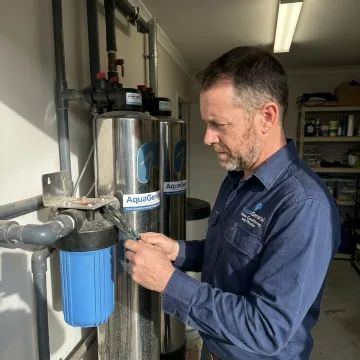 Technician inspecting a home water treatment system