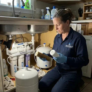 Technician replacing an under-sink water filter