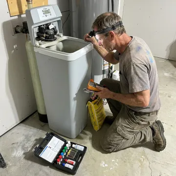 Technician servicing a residential water softener system