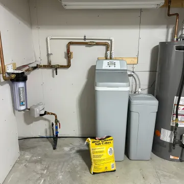 Water softener system installed in a home utility area