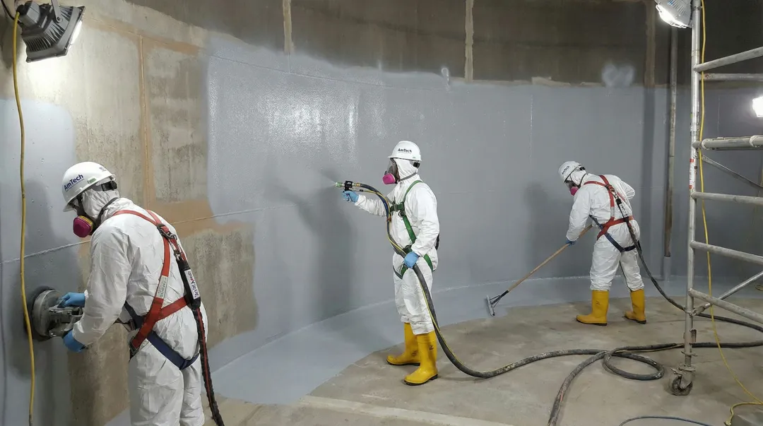 AmTech tank relining crew applying NSF-compliant epoxy lining inside large industrial water tank