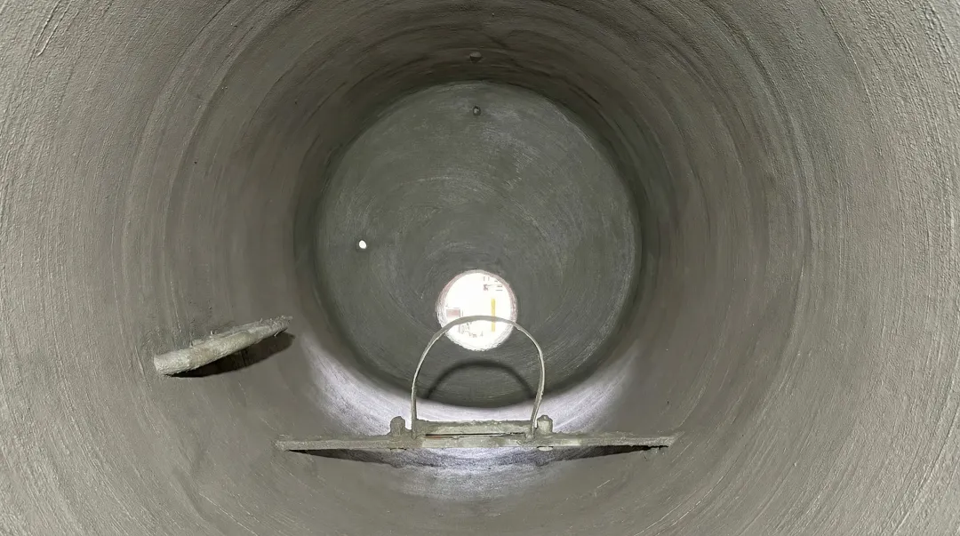 Underground steel tank interior showing full cementitious lining application and surface coating