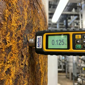 Close-up of ultrasonic thickness gauge on corroded tank surface