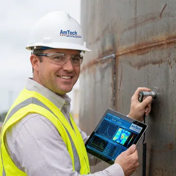 Close-up of technician analyzing ultrasonic testing data on tank wall