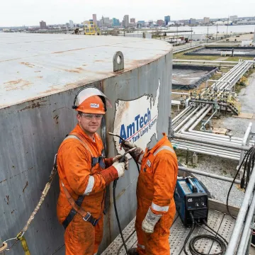 Industrial oil storage tank being repaired by certified technicians in Baltimore