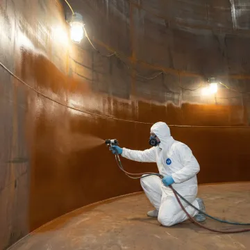 Technician applying industrial tank lining coating
