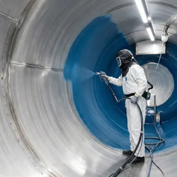 Technician applying industrial lining system inside ISO tank container
