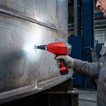 Technician performing ultrasonic testing on industrial storage tank