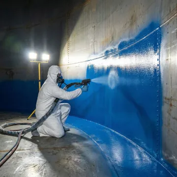 AmTech technician applying instant-cure tank lining system during emergency oil tank repair