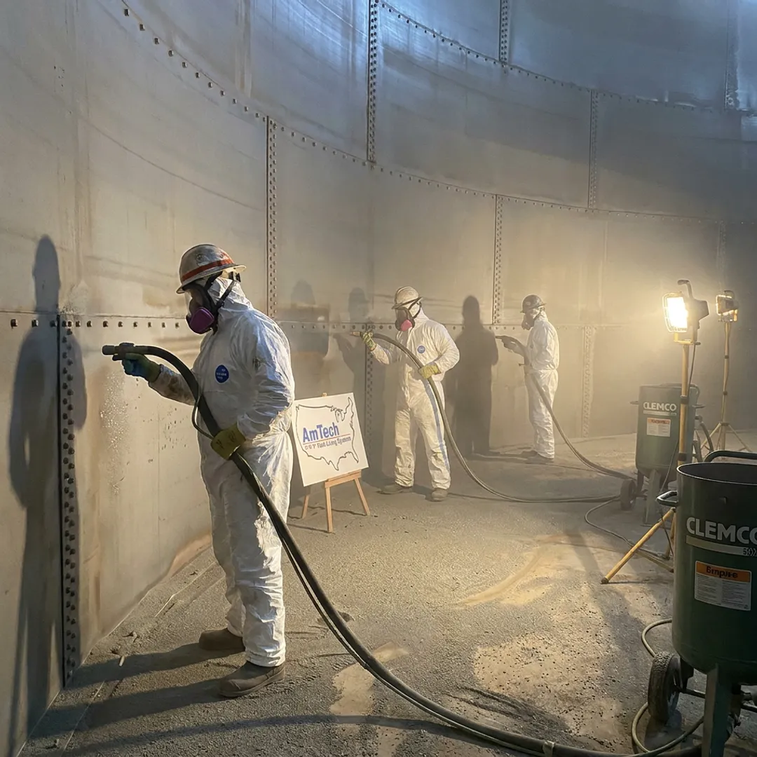 Crew preparing the interior of a steel tank for relining