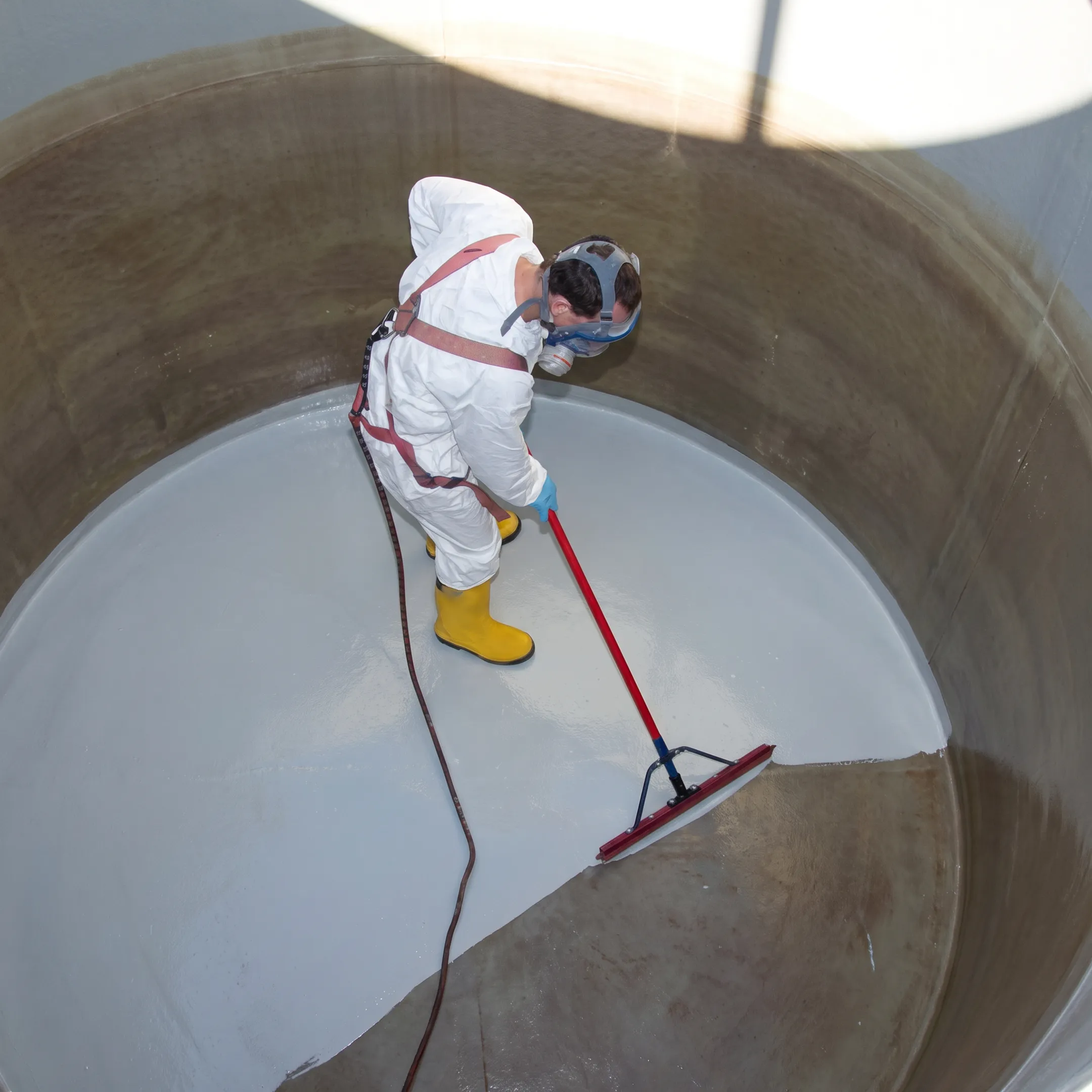 Technicians applying protective lining inside a fire suppression water tank
