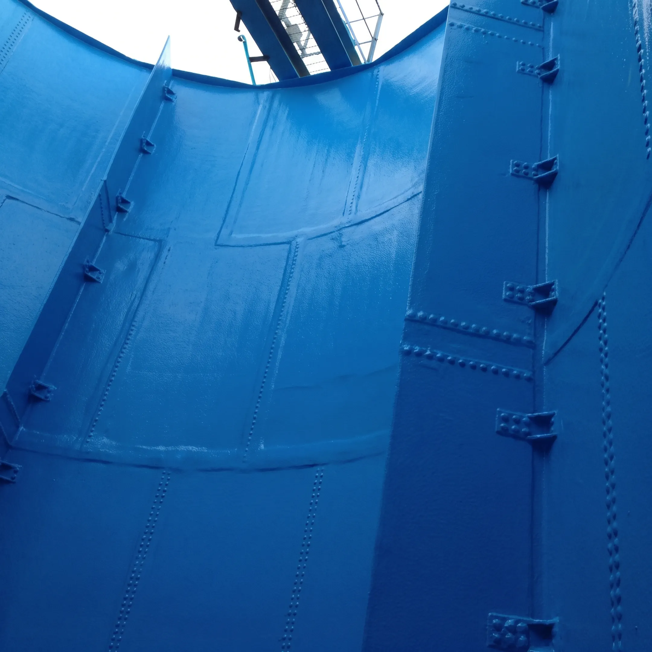 Seamless polyurea lining protecting a bolted steel tank interior