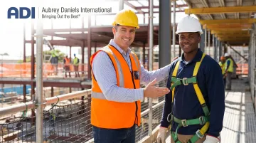 Construction site supervisor giving specific verbal recognition to worker for safe behavior