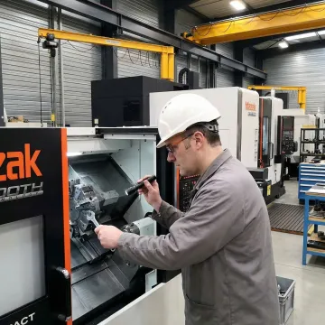 A.W. Miller engineer performing industrial machine maintenance in a manufacturing facility