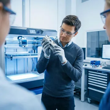 Professional engineer learning metal 3D printing techniques during a hands-on training course